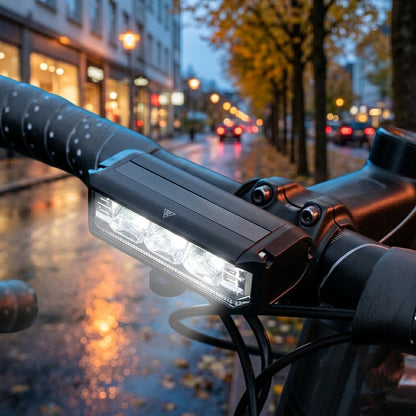 Cykellygte LED forlygte på styret på en våd bygade om efteråret